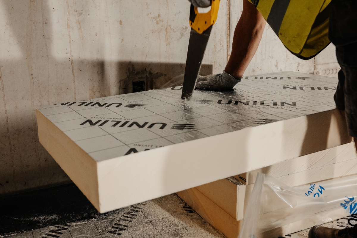 Matériaux isolants en PIR ou en PUR offrant des performances élevées et une installation simple. Une personne isolant son toit avec des panneaux PIR de la marque Unilin.